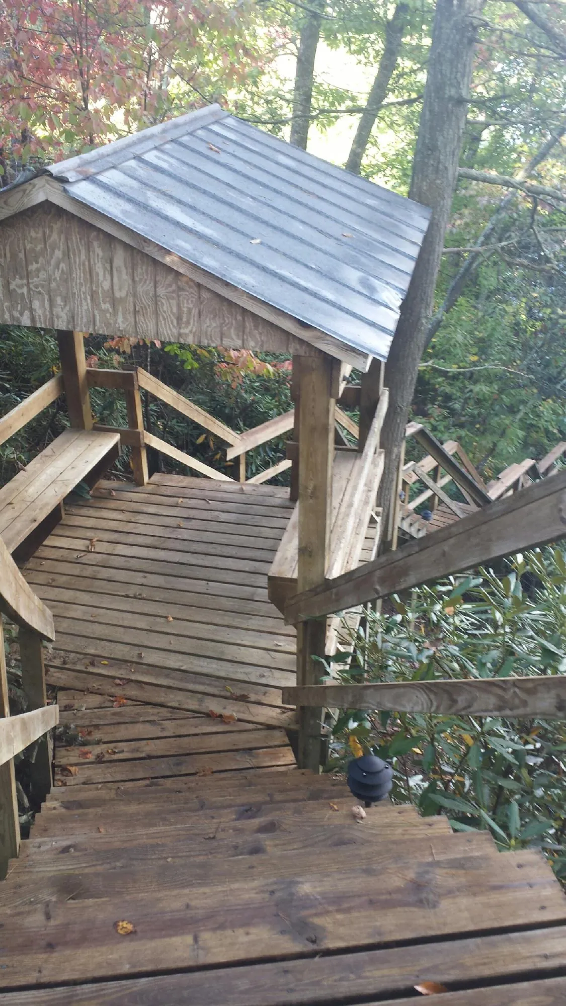 Metal roofed shelter over wooden steps on a wooded walkway — Skylight Repair & Installation work by our crew in Babylon