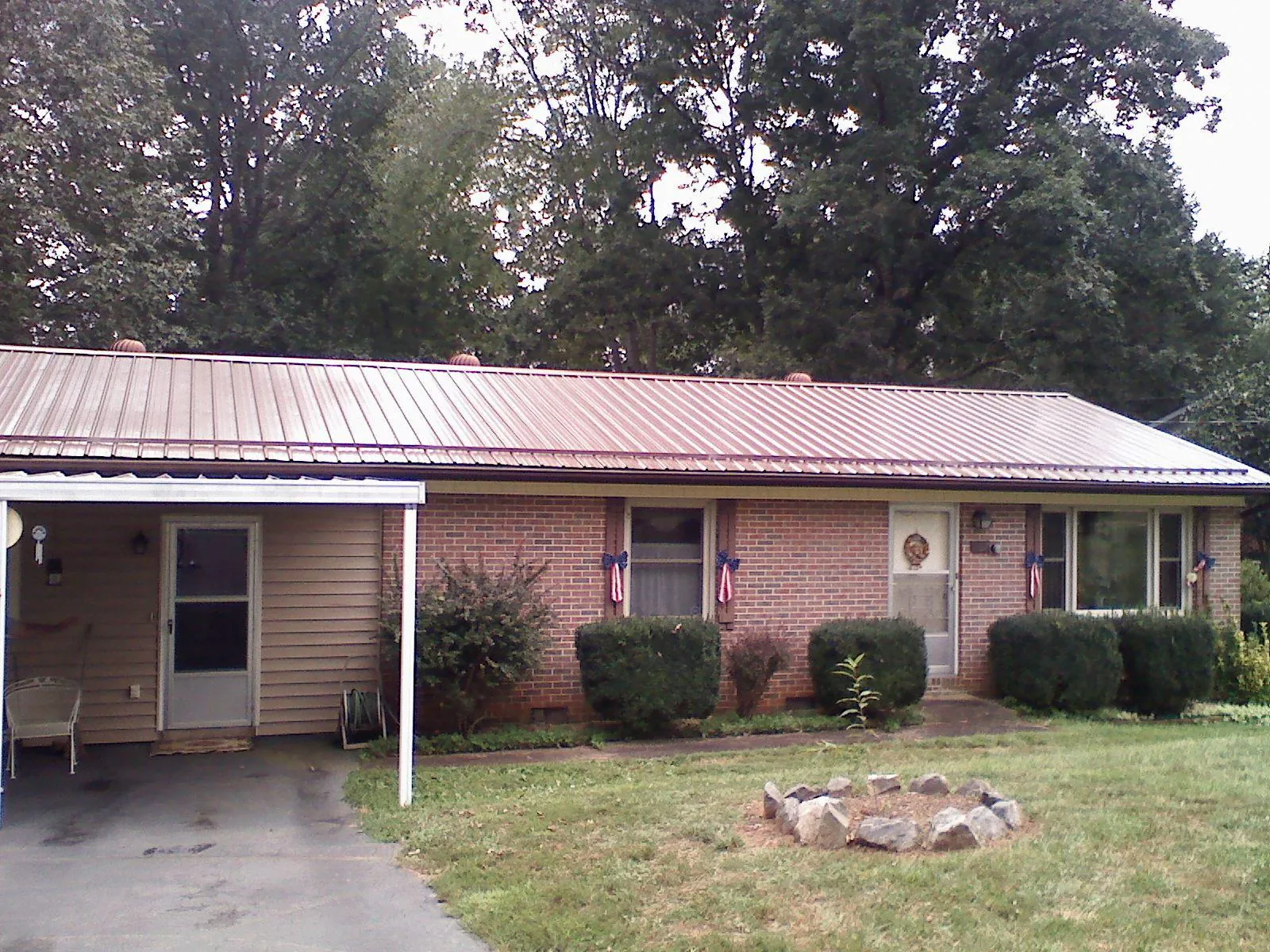 Bronze metal roof and carport on a brick ranch home — Roof Repair work by our crew in Babylon